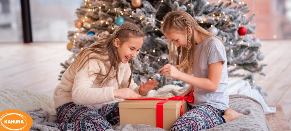 Young girls opening a gift under the Christmas tree