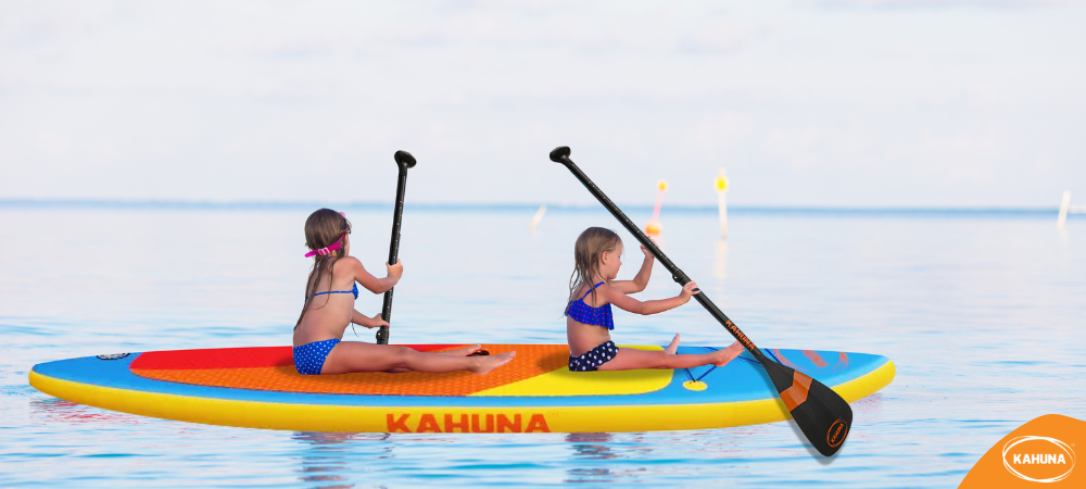 Two little girls paddling out on the water