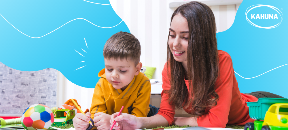 A young boy and his mom colouring indoors 