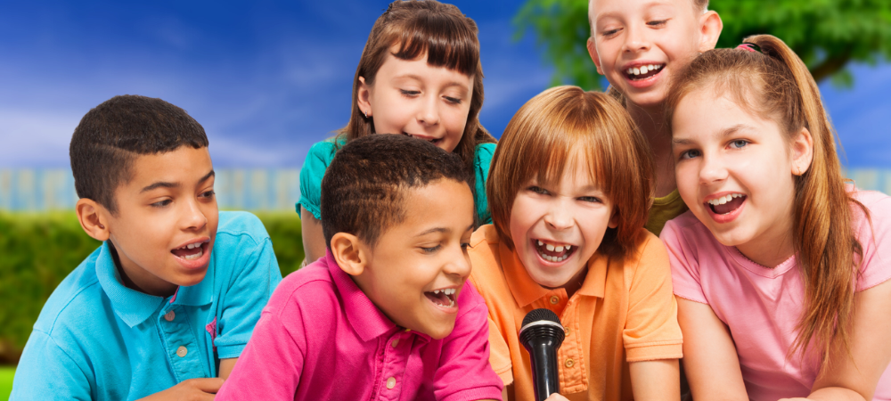 Diverse group of happy kids singing into a mic