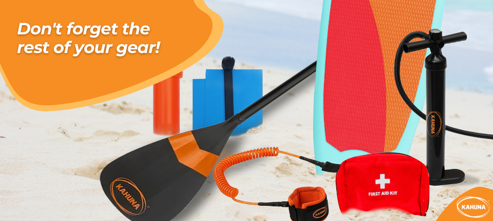 Kahuna paddle, leash and paddleboard next to a repair kit, pump and first aid kit