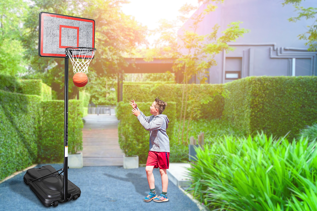 A young boy playing basketball in the garden