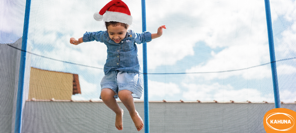 Young girl with a Santa hat jumping on a trampoline